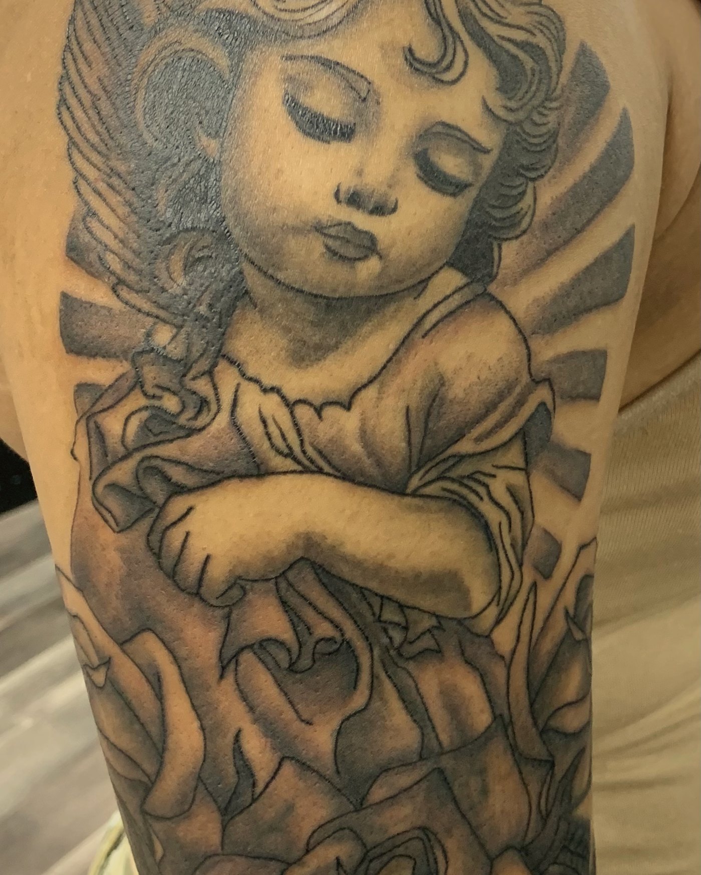 Black & grey cherub with roses — by Edwin Delarosa, Crown Ink Studio Brooklyn
