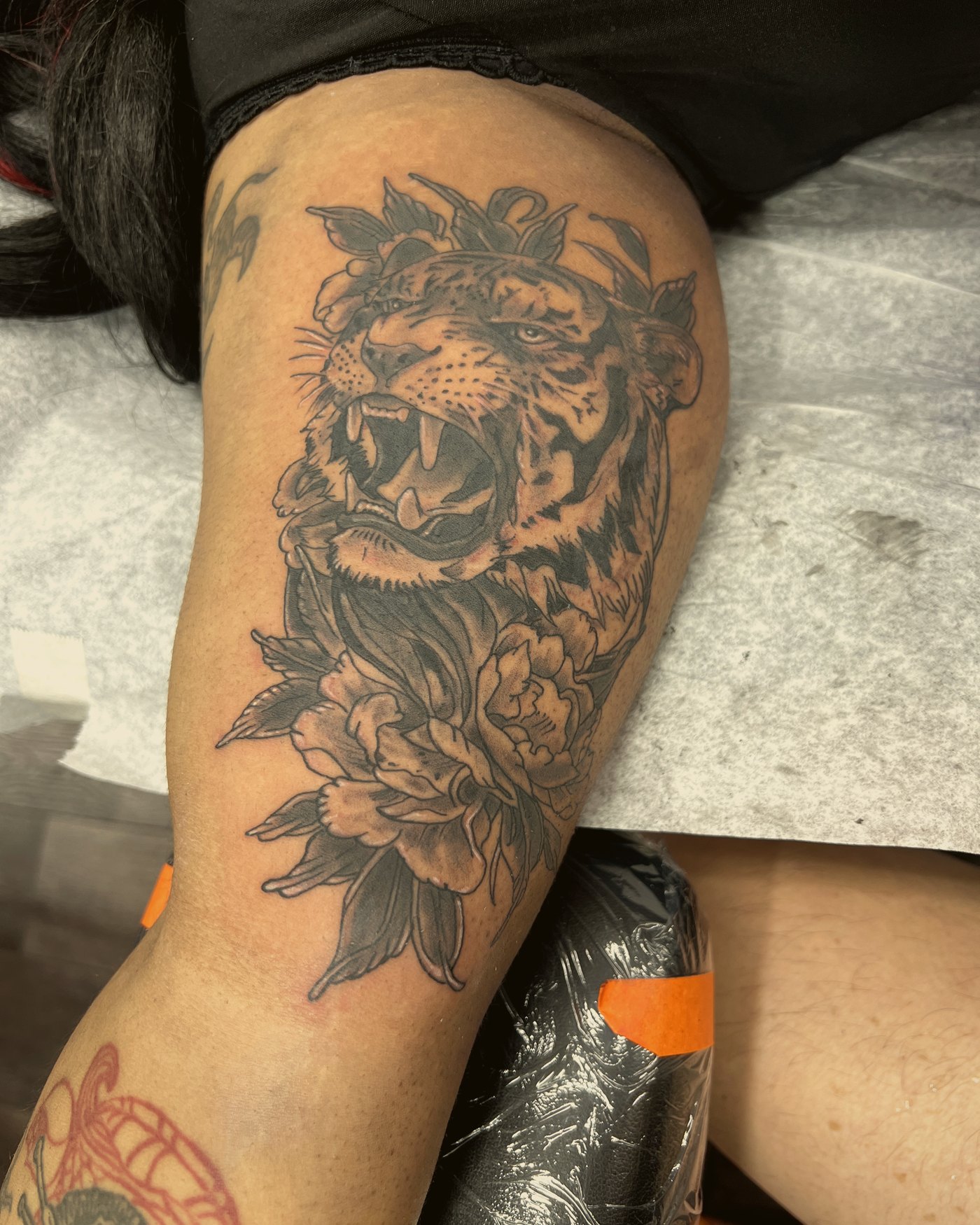 Lion with florals, black & grey, upper arm — by Paul Aroca, Crown Ink Studio Brooklyn